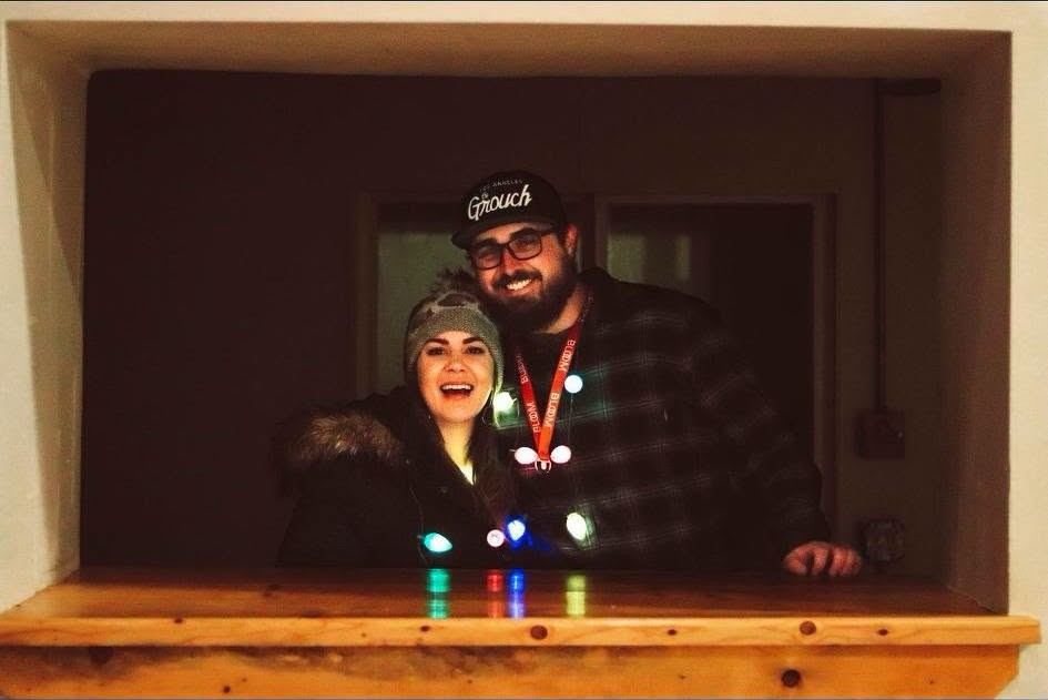 Ryan and Sara Jo celebrating in the building's front window on the day Sara bought it